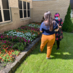 Two KaBloom judges look at red, pink, and white flower beds