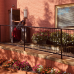 Staff member says hello and shows off flowers planted along entry ramp