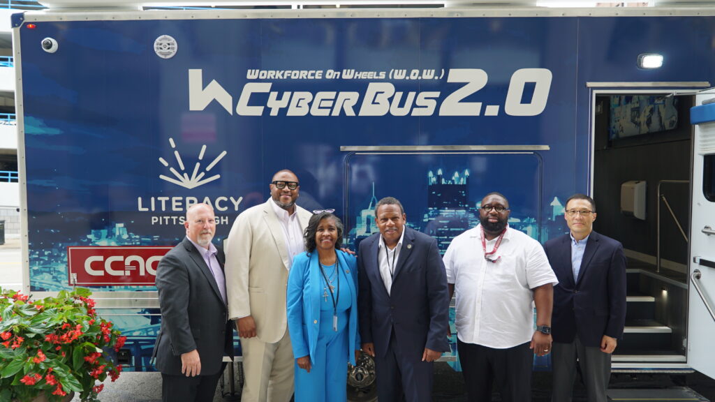 The HACP Executive, Resident Employment and Development & Modernization Staff pose in front of the CyberBus 2.0 with community partners from CVS and Oak St. Health.