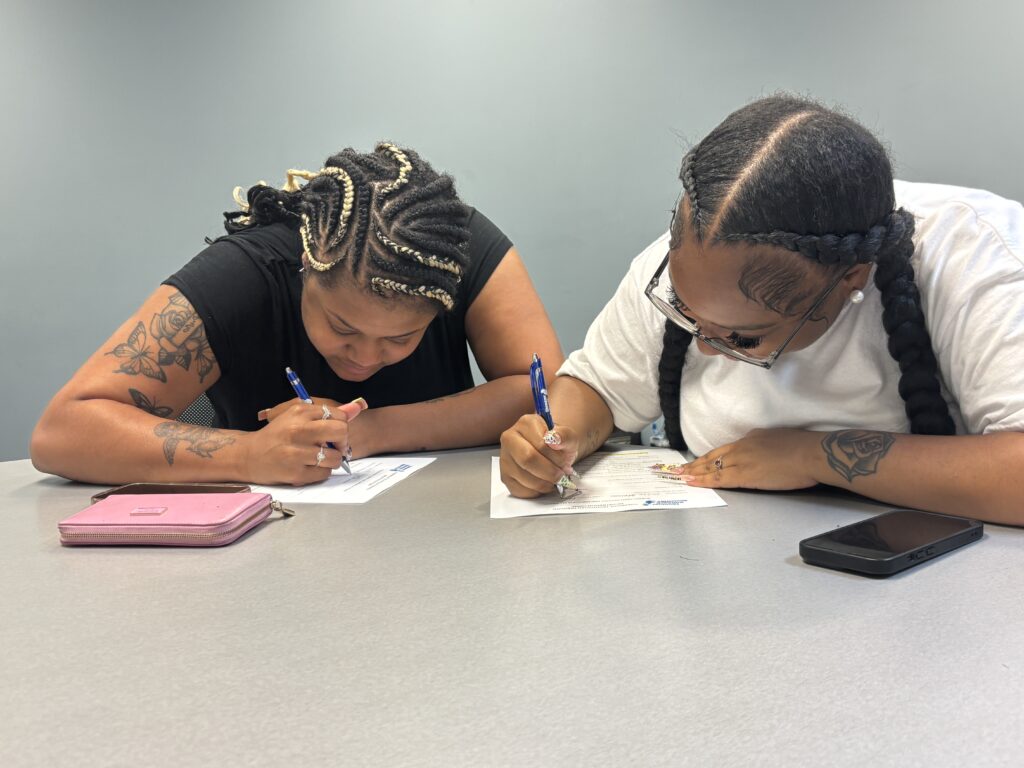 Prospective students fill out contact sheets for an upcoming CVS Health Pharmacy Tech Program cohort in the Hill District