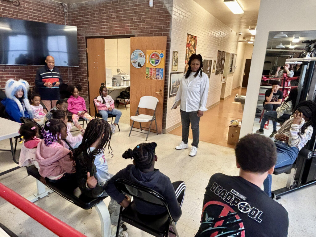 Coach Myrae Lee talks with children at Allegheny Dwellings
